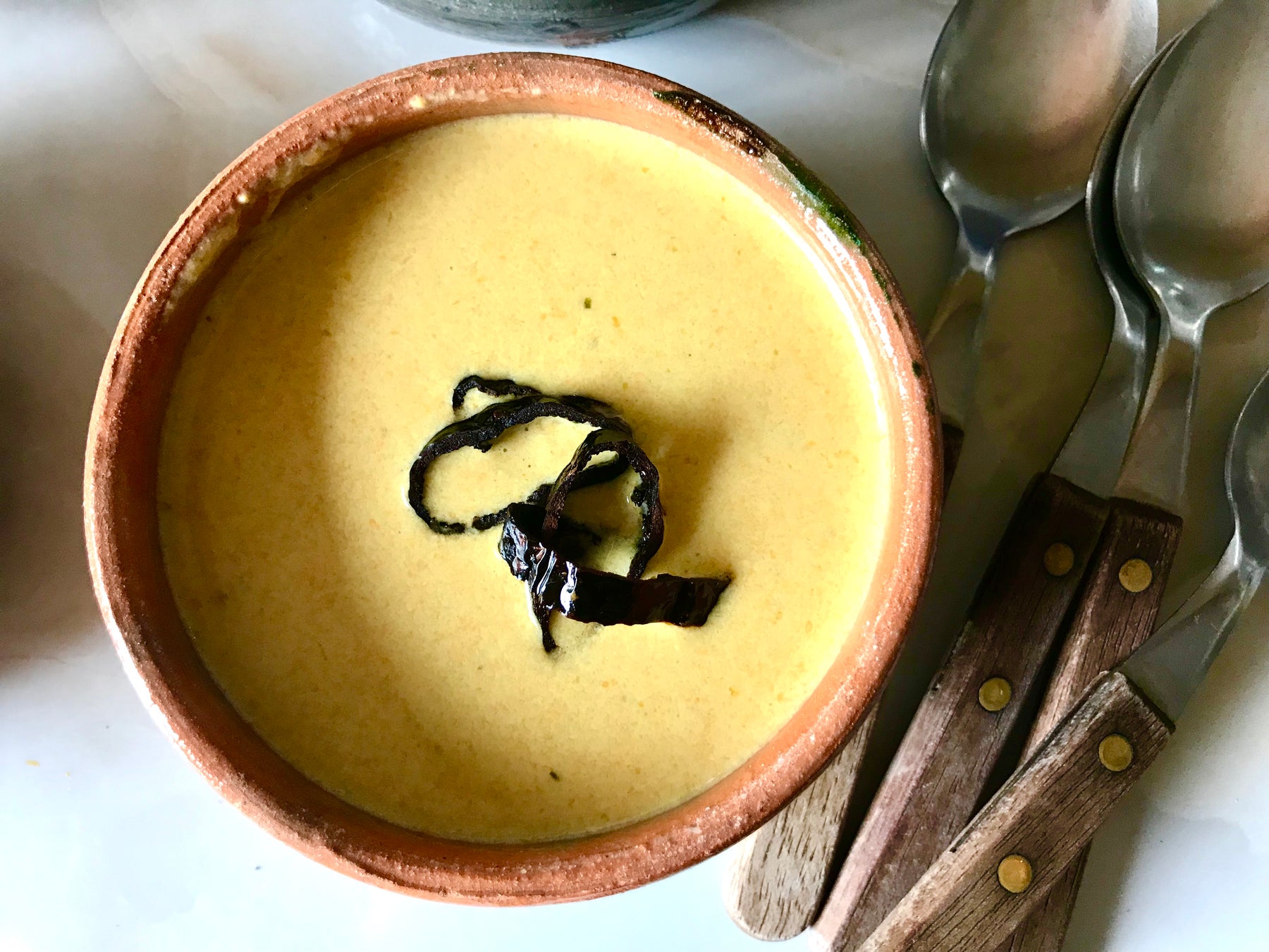 Squash Blossom Creme Soup served in orange and gray glazed clay bowls from Mexico 1492