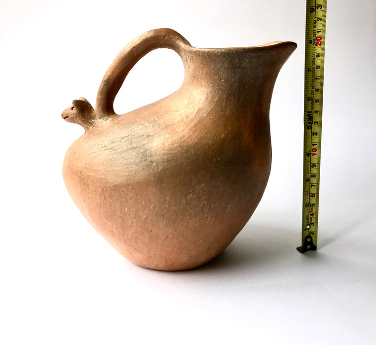 Mexico 1492: Stunning pitcher with an animal head ornament, made from red clay with a yellowish and gray tone and marked with random flame spots, adding character. Best for serving water, refreshing drinks, or even as a vase. Lead free, unglazed. Thanks to the artisanal nature of this handmade product, no two pieces are the same. 