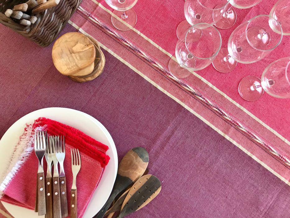 Mexico 1492: Pure cotton tablecloths with 4 stripes and braids, handmade on a pedal loom, by tenured, skillful artisans in one of the oldest, family-owned weaving workshops in Patzcuaro, Michoacan.   Available in 4 color combinations: Charcoal, Charcoal & Pebble, Pitaya & Grape and Oaxaca Sand. Each comes with 8 matching napkins.  L 2m (78.7") x W 2m (78.7")