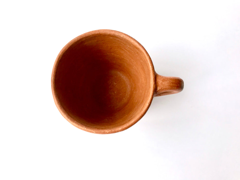 Mexico 1492: A rustic cup, made from red clay with a yellowish tone and marked with random flame spots, adding character. Best for serving coffee, tea, or hot chocolate. Lead free, unglazed. Thanks to the artisanal nature of this handmade product, no two pieces are the same. 