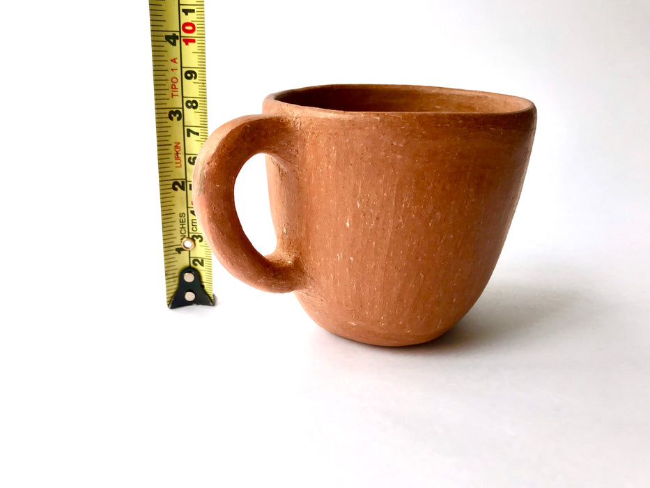 Mexico 1492: A rustic cup, made from red clay with a yellowish tone and marked with random flame spots, adding character. Best for serving coffee, tea, or hot chocolate. Lead free, unglazed. Thanks to the artisanal nature of this handmade product, no two pieces are the same. 